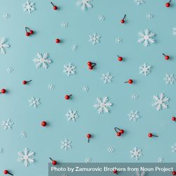 Christmas pattern made of snowflakes and red berries on blue background 0KgQz0
