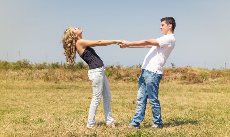 Love couple holding hands outdoors on a summer day