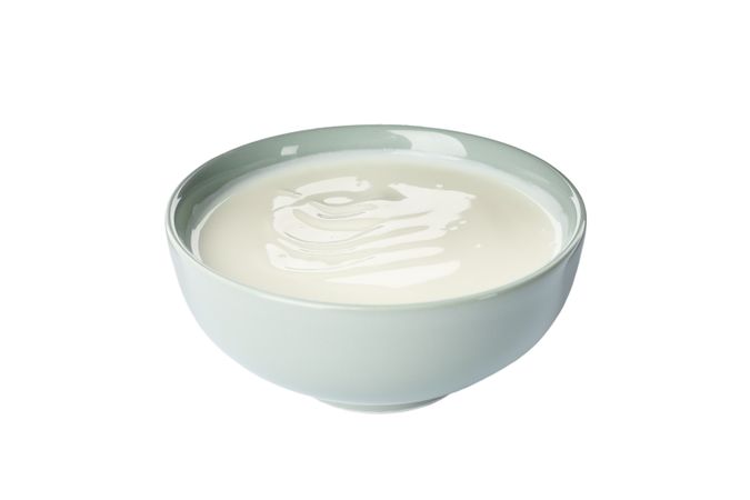Bowl of sour cream yogurt isolated on light background