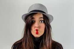 Woman gesturing with her red lips over gray background