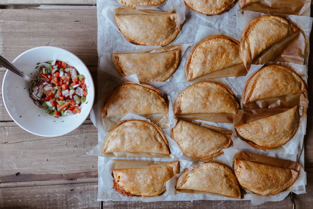 Baking tray with composed freshly baked pies patty