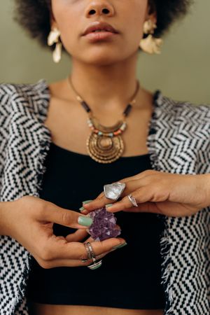Black woman holding purple gemstone