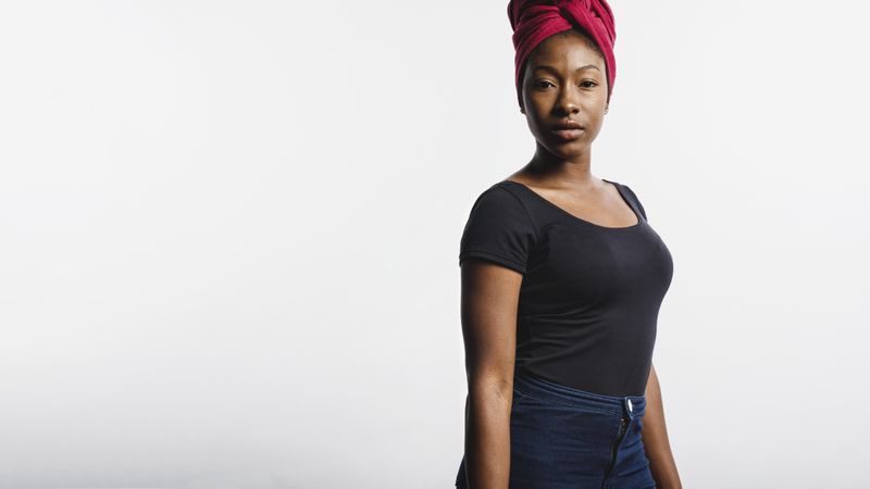 Side view of an African woman in jeans isolated on neutral background
