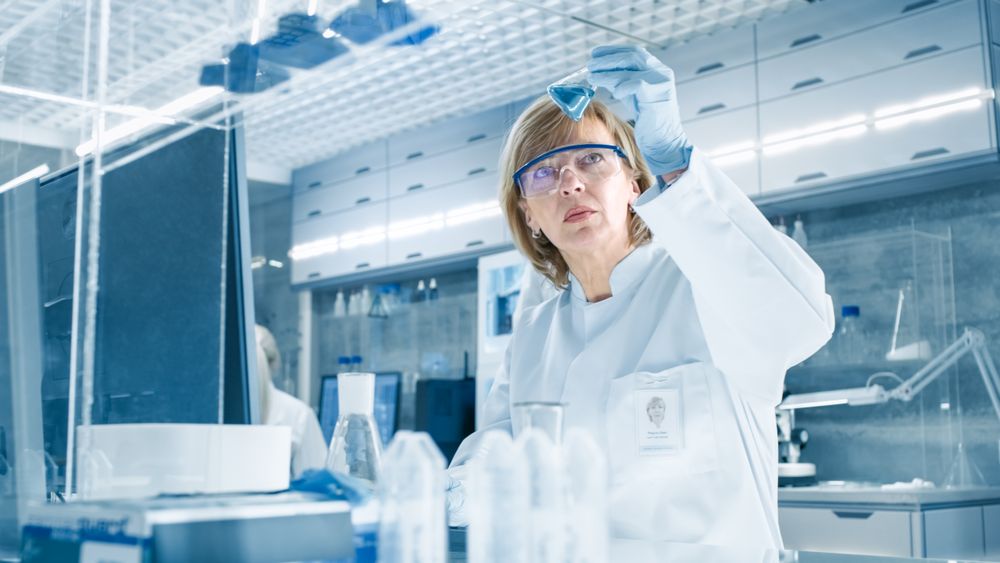 Shot of High Tech Ultra Modern Laboratory with Mature Womsn Scientists Conducting experiments and Mixing Chemicals.