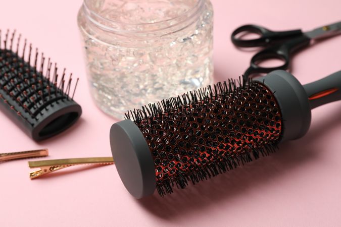 Composition with hairdresser accessories on pink background, close up