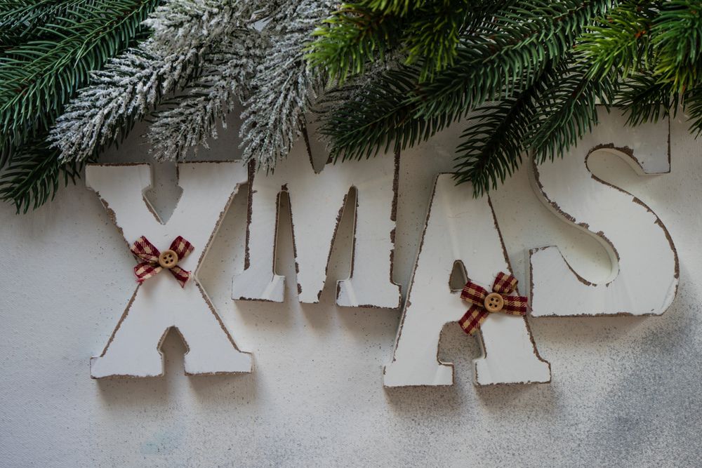 XMAS spelled in wooden letters with Christmas pine