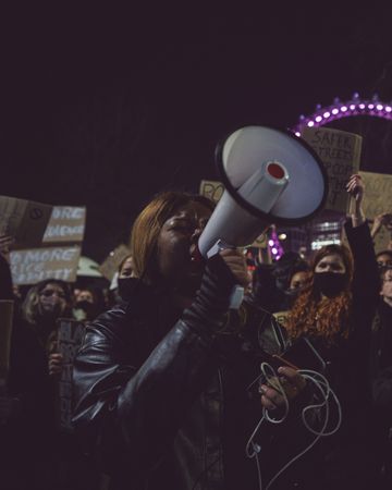 London, England, United Kingdom - March 16, 2021: Woman with speaker phone at large protest