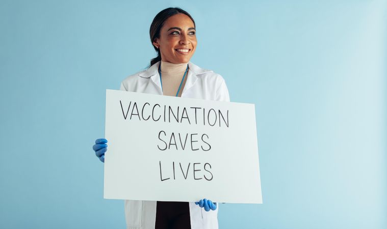 Vaccination saves lives banner in hands of a female healthcare professional