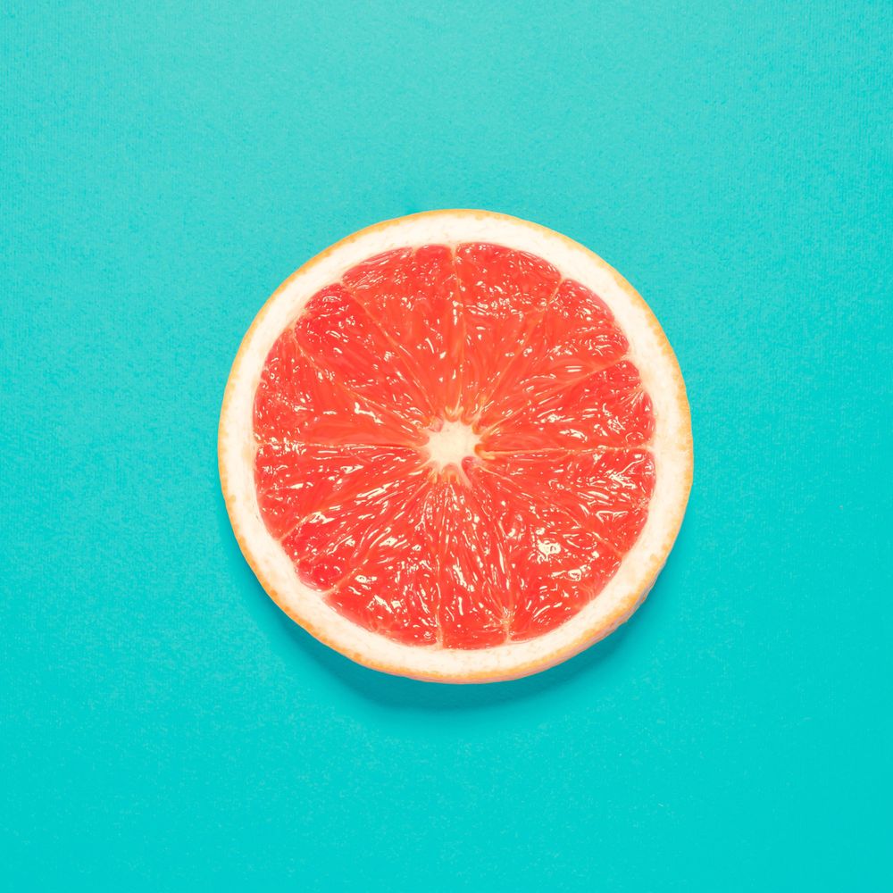 Grapefruit half on bright blue background