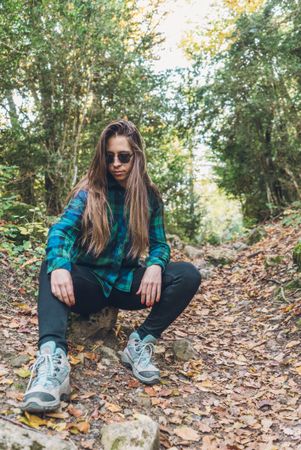 Stylish female teenager in casual outfit at autumn forest