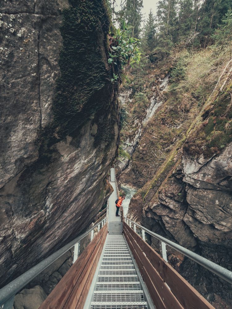 Tourist on hiking path among rocky slopes