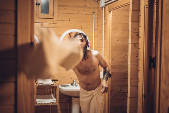Bearded man throwing towel after bathing