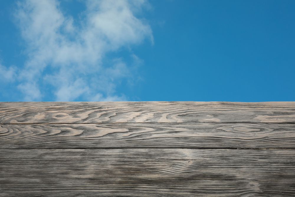 Wooden table against blue skies, space for text. Mockup