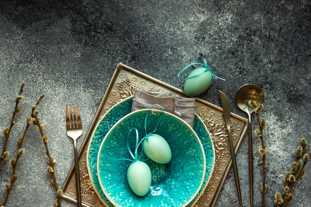 Teal bowl with pastel egg ornaments for table setting