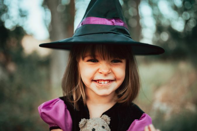 Portrait of happy cute girl dressed as a witch