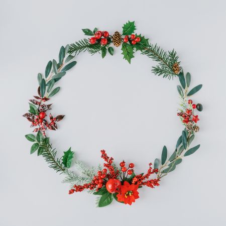 Flat lay of holiday wreath on light background