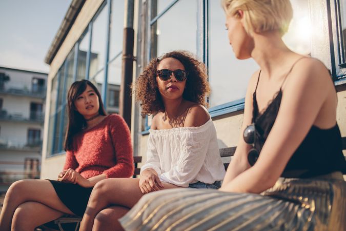 Multiracial group of young women sitting outdoors and chatting