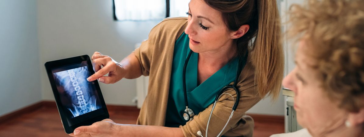 Female doctor showing an x-ray on the tablet