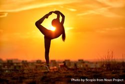 Silhouette of girl doing dancer pose during sunset 5XWpK0