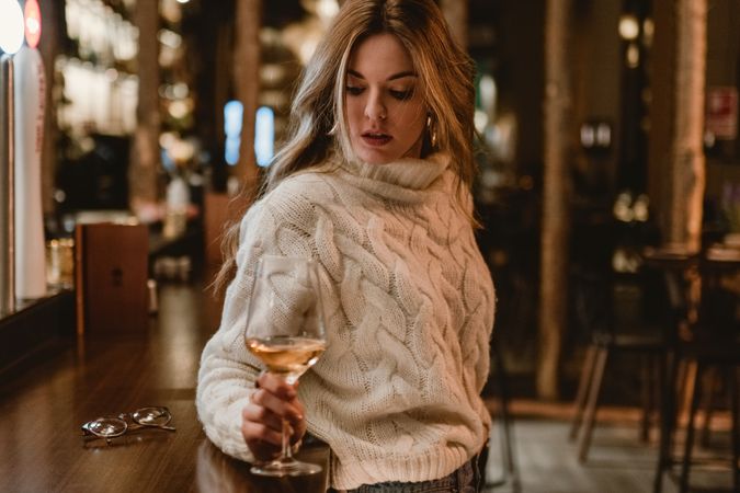 Stylish woman drinking wine in bar