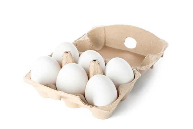 chicken eggs in carton box isolated on plain background