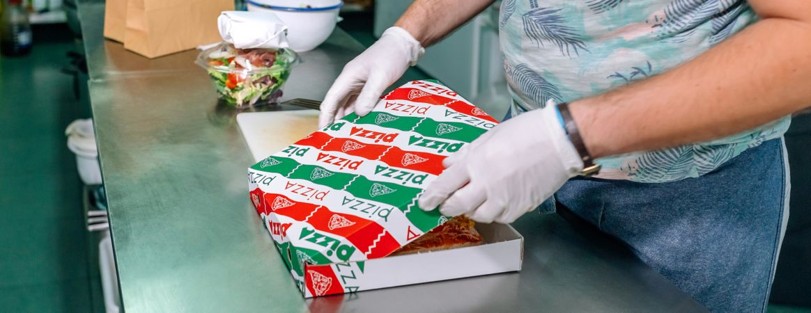 Unrecognizable cook preparing pizza to takeaway