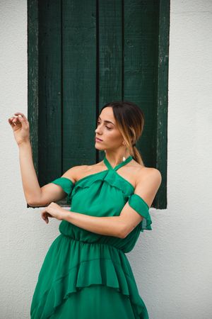Barefoot woman leaning on house wall