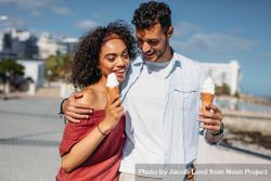 Couple in love walking on city street eating ice creams 4j8pz0