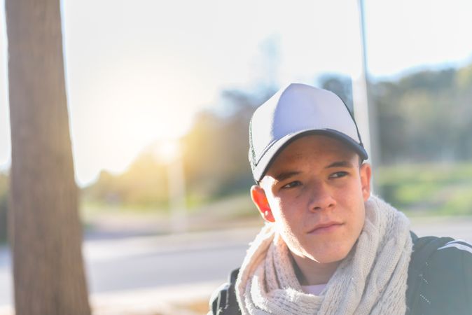 Teenage male sitting outside with cap