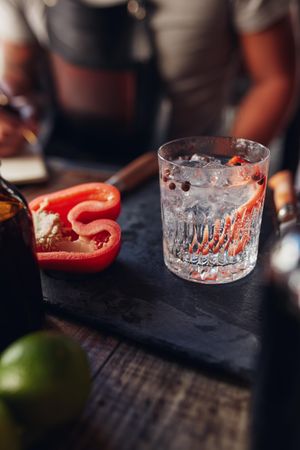 Sliced red pepper next to a clear cocktail