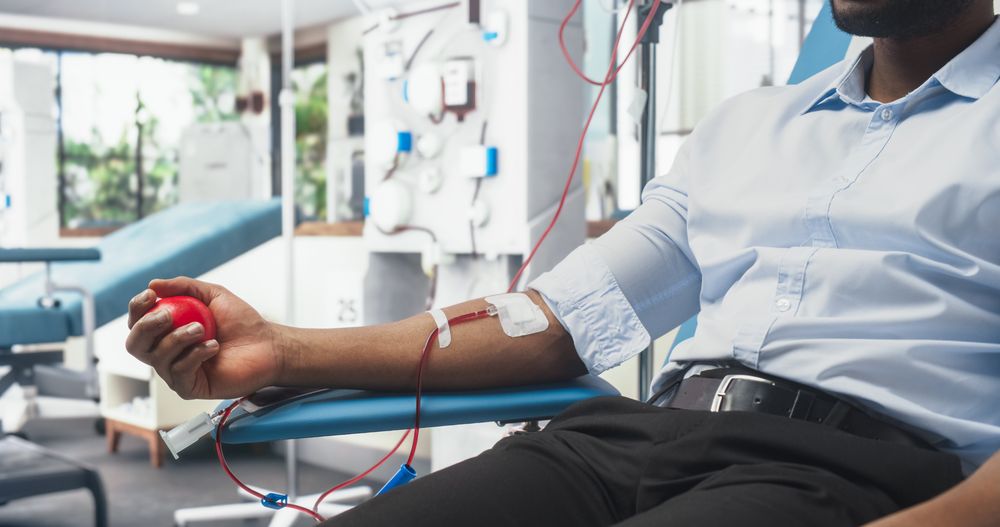 Close Up Shot Of Hand Of Black Male Blood Donor With an Attached Catheter.