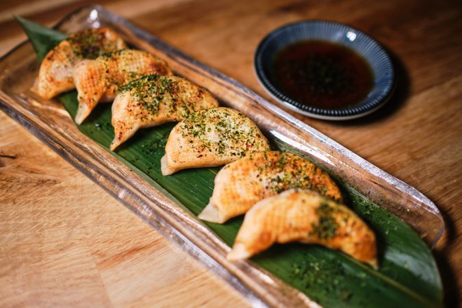 Delicious dumplings with seasoning served on glass plate