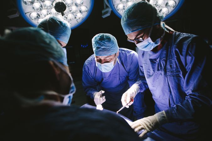 Team of professional surgeons performing surgery in operation room