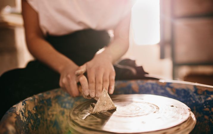 Hands of female potter working at potters wheel