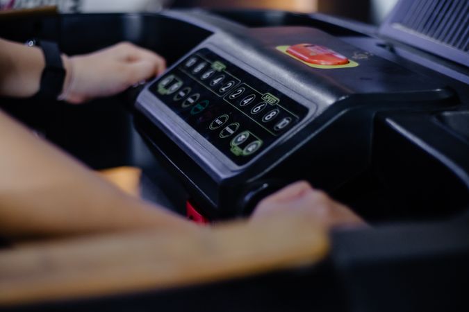Hands control the treadmill, exercising for health improvement