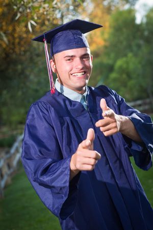 Male Graduate in Cap and Gown Outside.