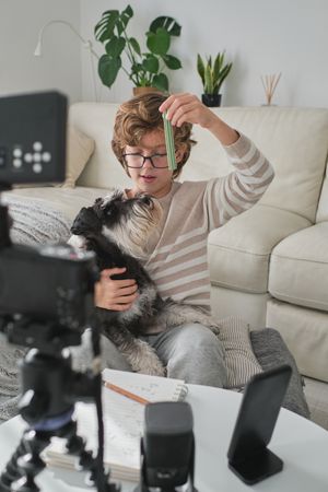 Boy shooting video for blog with dog