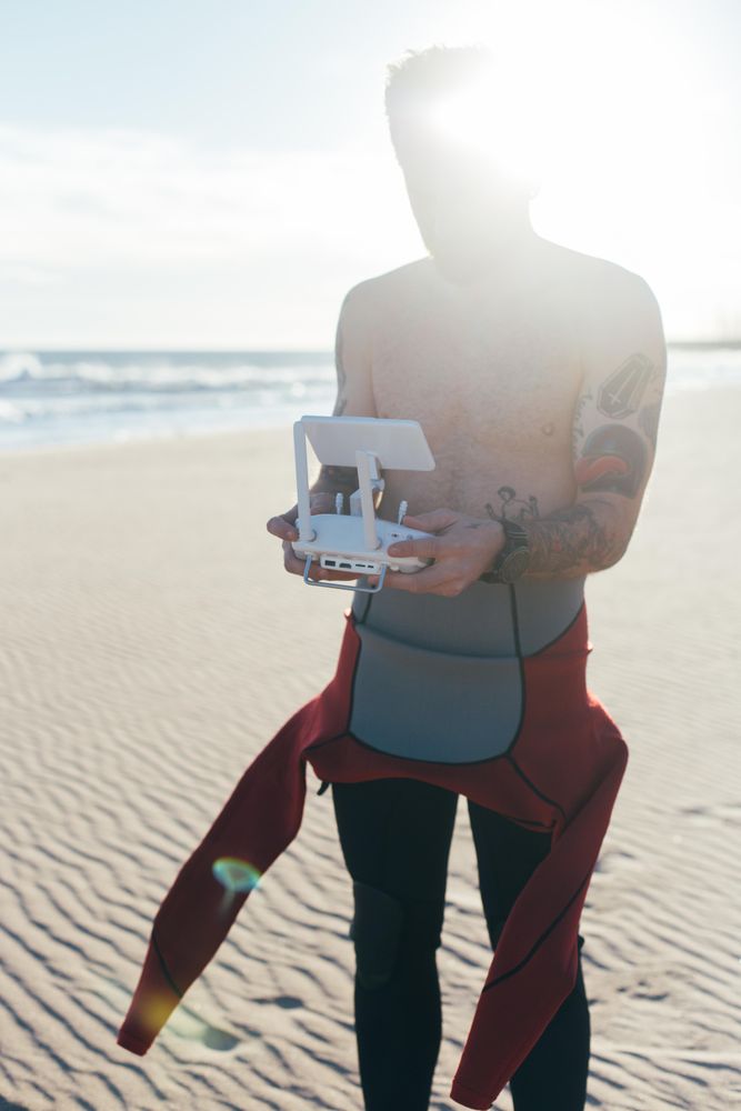 Man in wetsuit with drone