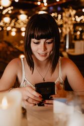 Smiling woman using smartphone in restaurant