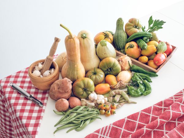Various fresh vegetables and utensils on table
