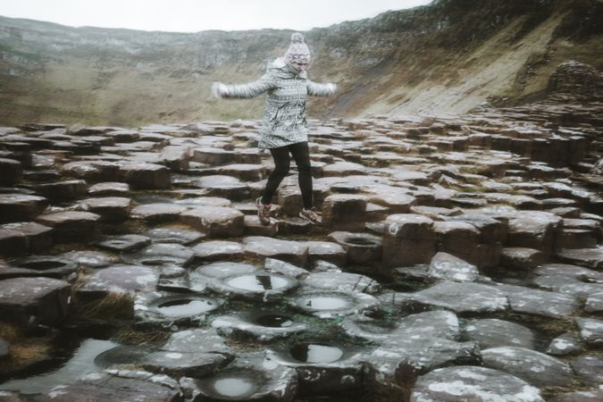 Female standing on cliff and contemplating
