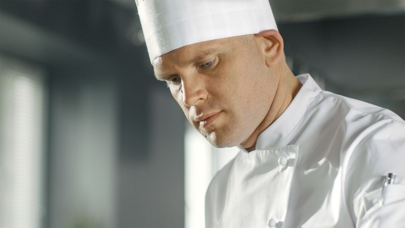 Close-up of a Famous Chef Concentrated on Cooking Perfect Dish.