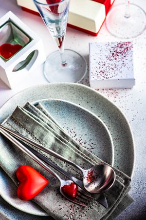 Valentine Day holiday card concept with table setting of hearts and red glitter