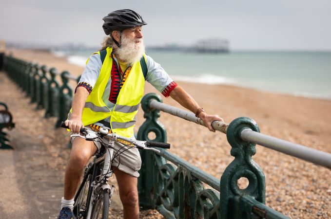 Calm older man enjoying coastal view from bike