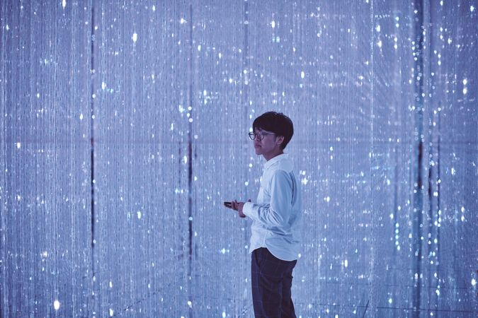 Tokyo, Japan - November 19th, 2019: Young man standing in crystalline art installation