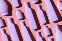 Light pink painted glass bottles on pink background