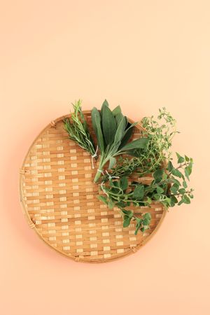 Looking down at thatched basket with different herbs