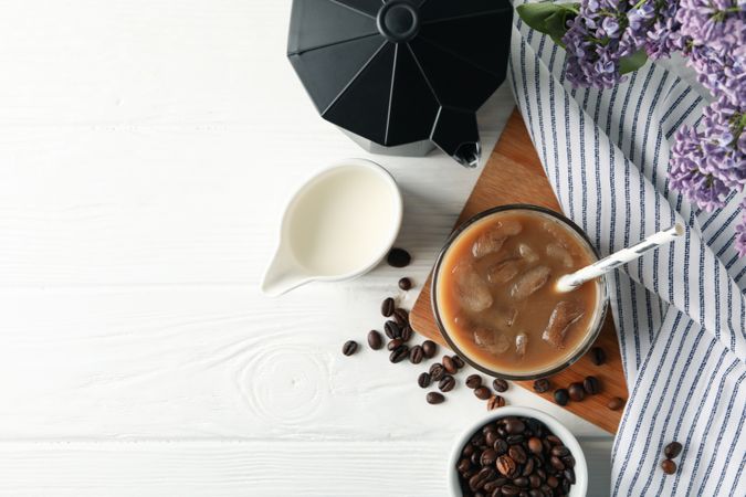 Composition with ice coffee and flowers on wooden background