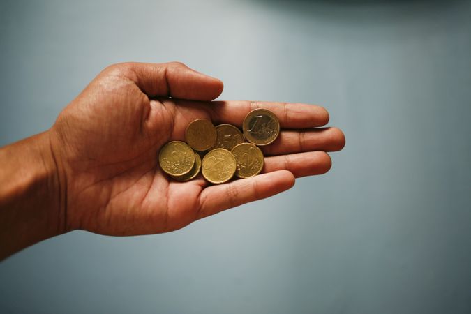 Man’s hand holding coins