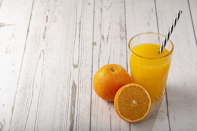 Glass with orange juice on the table.
